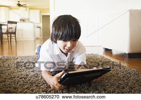 Boy (8-9) using digital tablet View Large Photo Image Stock Image - Boy (8-9) using digital tablet. Fotosearch