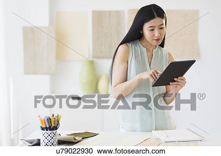 Stock Image - Business woman using tablet pc. Fotosearch