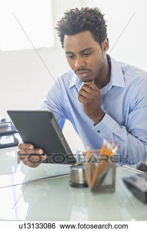 Businessman using tablet PC in office View Large Photo Image Stock Photograph - Businessman using tablet PC in office. Fotosearch