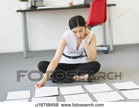 Businesswoman organizing paperwork on floor View Large Photo Image Stock Photo - Businesswoman organizing paperwork on floor. Fotosearch