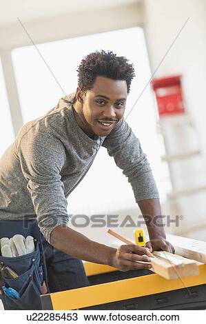 Carpenter measuring plank View Large Photo Image Stock Image - Carpenter measuring plank. Fotosearch