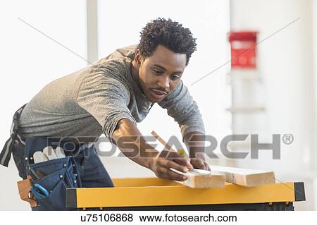 Carpenter measuring plank View Large Photo Image Stock Photo - Carpenter measuring plank. Fotosearch