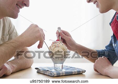 Couple eating one bowl of ice-cream View Large Photo Image Stock Photo - Couple eating one bowl of ice-cream. Fotosearch