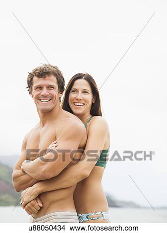 Picture - Couple embracing on beach. Fotosearch