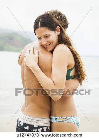Stock Image - Couple embracing on beach. Fotosearch