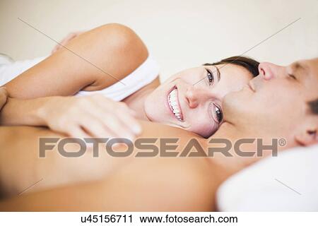 Stock Image - Couple lying on bed. Fotosearch