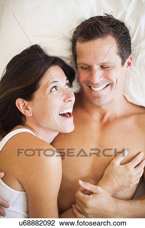 Stock Image - Couple lying on bed. Fotosearch