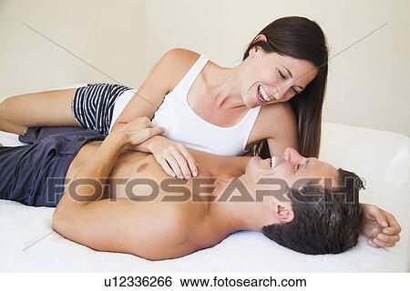 Couple lying on bed View Large Photo Image Stock Photograph - Couple lying on bed. Fotosearch