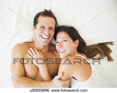 Couple lying on bed View Large Photo Image Stock Photograph - Couple lying on bed. Fotosearch