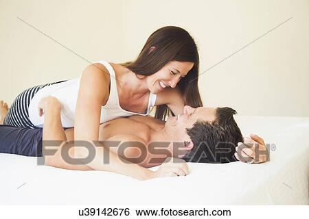 Couple lying on bed View Large Photo Image Stock Photograph - Couple lying on bed. Fotosearch