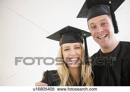 Stock Photography - Couple of friends in graduation gowns. Fotosearch