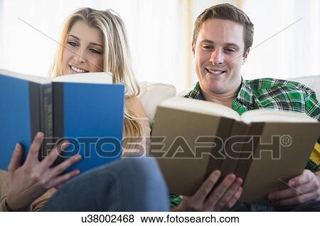 Stock Photo - Couple on sofa reading. Fotosearch