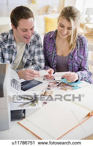 Couple preparing photo album View Large Photo Image Stock Image - Couple preparing photo album. Fotosearch