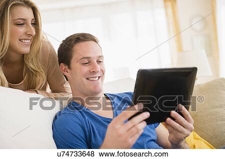 Couple using digital tablet View Large Photo Image Stock Photo - Couple using digital tablet. Fotosearch