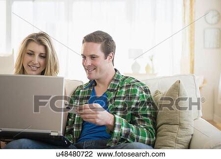 Couple using laptop, shopping online View Large Photo Image Stock Image - Couple using laptop, shopping online. Fotosearch