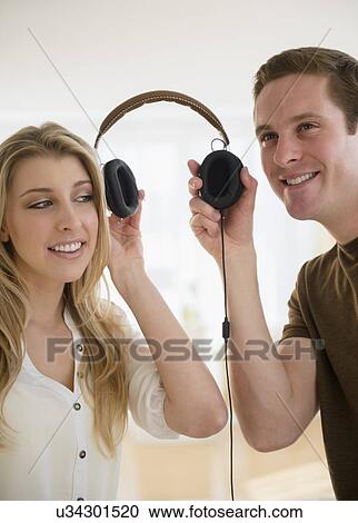 Couple using one headset together View Large Photo Image Stock Image - Couple using one headset together. Fotosearch