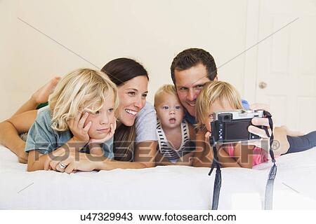 Family with three kids (6-7, 2-3, 6-11 months) photographing themselves View Large Photo Image Stock Image - Family with three kids (6-7, 2-3, 6-11 months) photographing themselves. Fotosearch