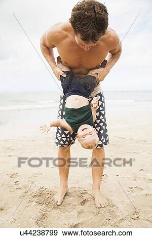Father with son (6-11 months) on beach View Large Photo Image Stock Photo - Father with son (6-11 months) on beach. Fotosearch