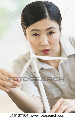 Female engineer working on model of wind turbine View Large Photo Image Picture - Female engineer working on model of wind turbine. Fotosearch