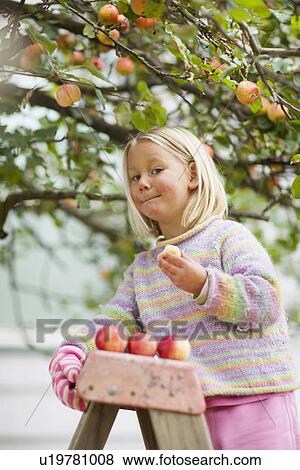 Stock Photo - Girl (2-3) tasting apple. Fotosearch