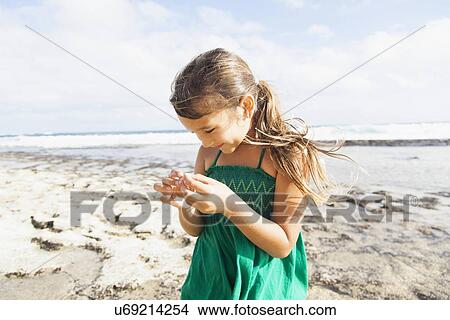 Picture - Girl (6-7) playing on beach. Fotosearch