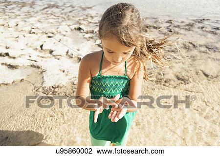 Girl (6-7) playing on beach View Large Photo Image Stock Image - Girl (6-7) playing on beach. Fotosearch