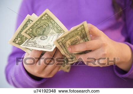 Stock Photo - Girl (8-9) counting money. Fotosearch