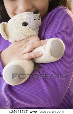 Girl (8-9) holding teddy bear View Large Photo Image Stock Photo - Girl (8-9) holding teddy bear. Fotosearch