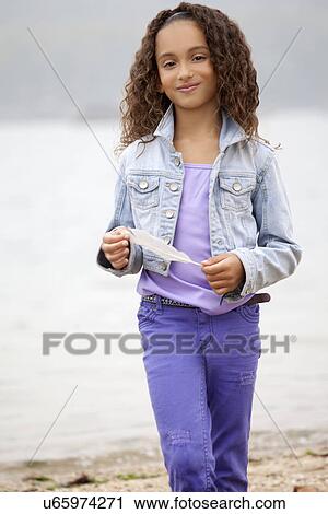 Stock Image - Girl (8-9) on Sea Cliff. Fotosearch