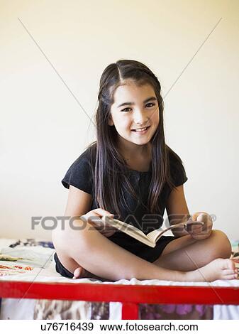 Girl (8-9) reading book View Large Photo Image Stock Photo - Girl (8-9) reading book. Fotosearch