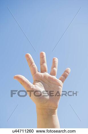 Stock Image - Girl's (8-9) palm against blue sky. Fotosearch