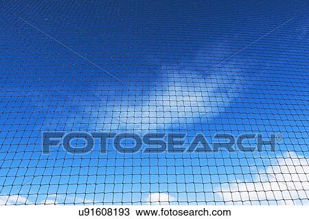 Stock Image - Grid-wire fence against sky. Fotosearch