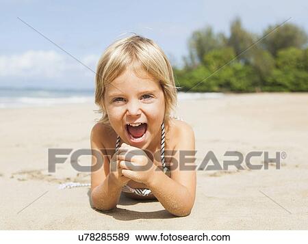 Stock Photo - Happy girl (2-3) on sandy beach. Fotosearch