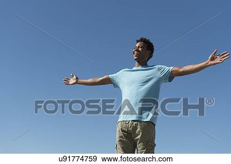 Happy man against clear sky View Large Photo Image Stock Photo - Happy man against clear sky. Fotosearch