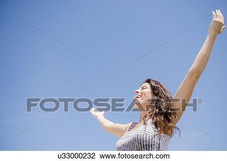 Happy woman against blue sky View Large Photo Image Stock Image - Happy woman against blue sky. Fotosearch
