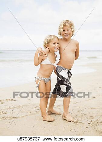 Laughing sibling on beach View Large Photo Image Stock Photo - Laughing sibling on beach. Fotosearch