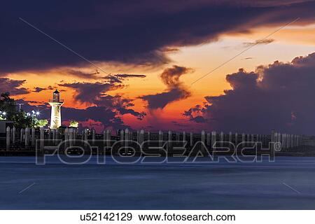 Stock Photo - Lighthouse with dramatic sky in background. Fotosearch