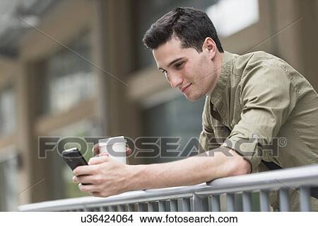 Man drinking coffee and text messaging View Large Photo Image Picture - Man drinking coffee and text messaging. Fotosearch