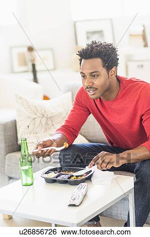 Man eating dinner and watching television View Large Photo Image Stock Photograph - Man eating dinner and watching television. Fotosearch