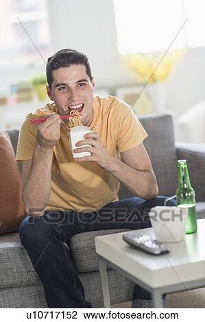 Man eating take out meal and watching television View Large Photo Image Stock Image - Man eating take out meal and watching television. Fotosearch