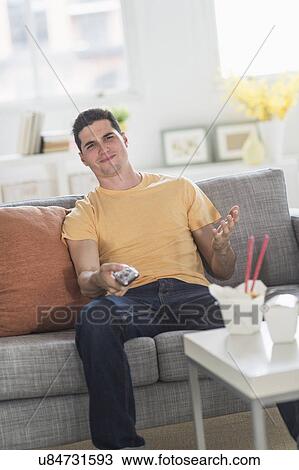 Man eating take out meal and watching television View Large Photo Image Stock Image - Man eating take out meal and watching television. Fotosearch