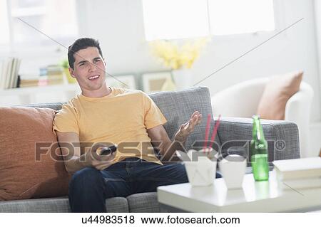 Man eating take out meal and watching television View Large Photo Image Stock Photo - Man eating take out meal and watching television. Fotosearch