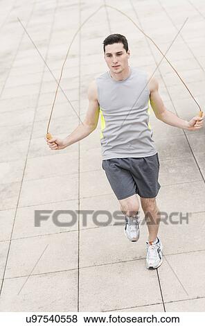 Stock Photo - Man exercising with jumping rope. Fotosearch