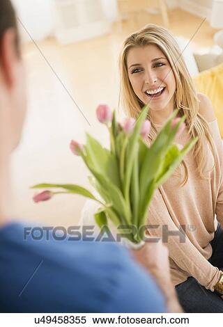 Stock Photography - Man giving his girl flowers. Fotosearch