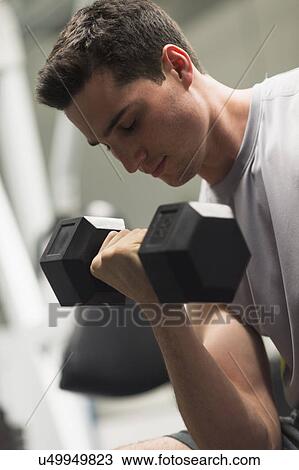 Stock Image - Man lifting dumbbells. Fotosearch