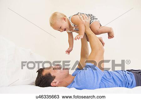 Man playing with baby boy (6-11 months) View Large Photo Image Stock Image - Man playing with baby boy (6-11 months). Fotosearch