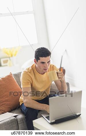 Man using laptop at home View Large Photo Image Stock Photo - Man using laptop at home. Fotosearch