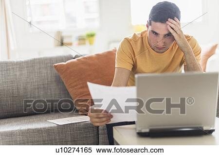 Stock Photography - Man using laptop at home. Fotosearch