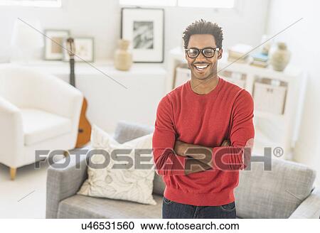 Man wearing spectacles standing in living room View Large Photo Image Stock Image - Man wearing spectacles standing in living room. Fotosearch