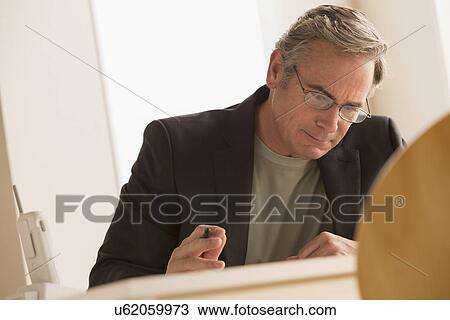 Stock Image - Mature business man concentrating on work. Fotosearch